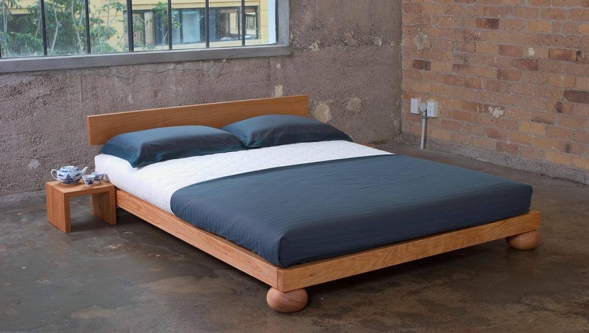 Macrocarpa bed frame with organic latex mattress and side table